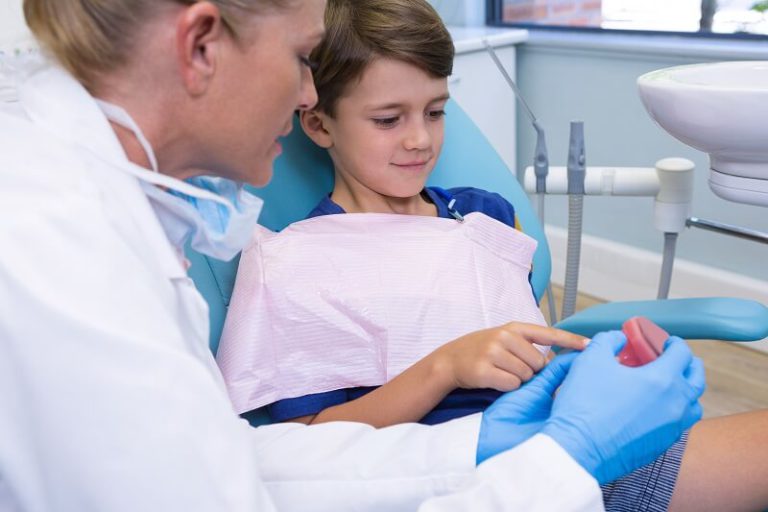 dentist and boy looking at dentures 39UNHZF