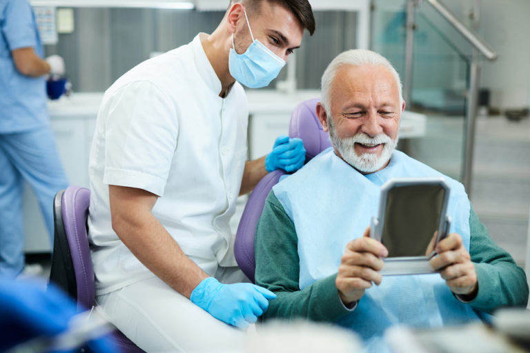 satisfied senior man looking his teeth in a mirror 2022 11 09 03 48 34 utc 1