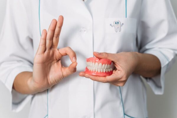 dental-prosthesis-in-the-hands-of-the-doctor-close-2022-02-02-20-34-18-utc (1)